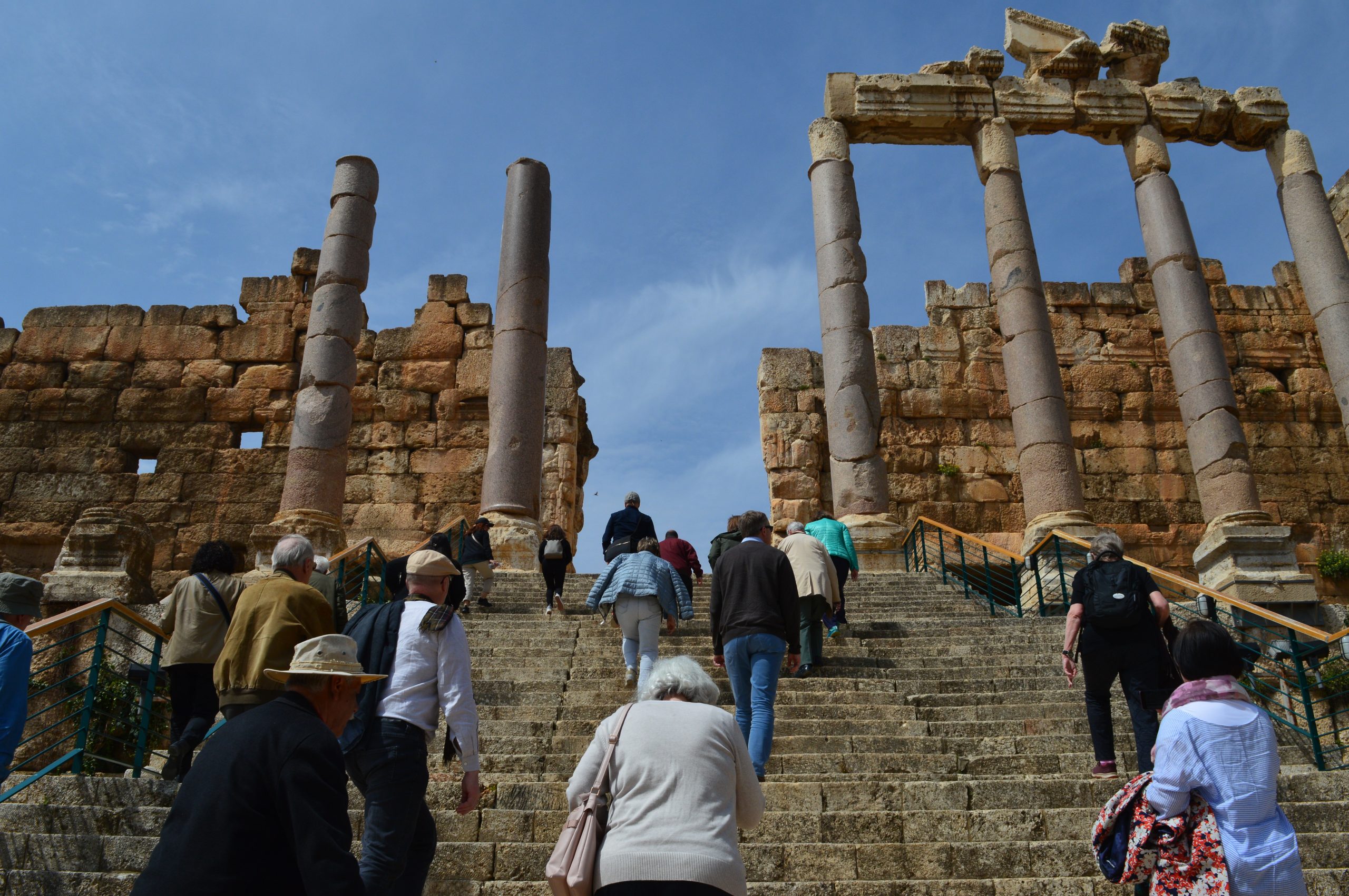 Kuvassa portaat, joiden päässä muinaisia pylväitä. Portaita kiipeää ryhmä ihmisiä.